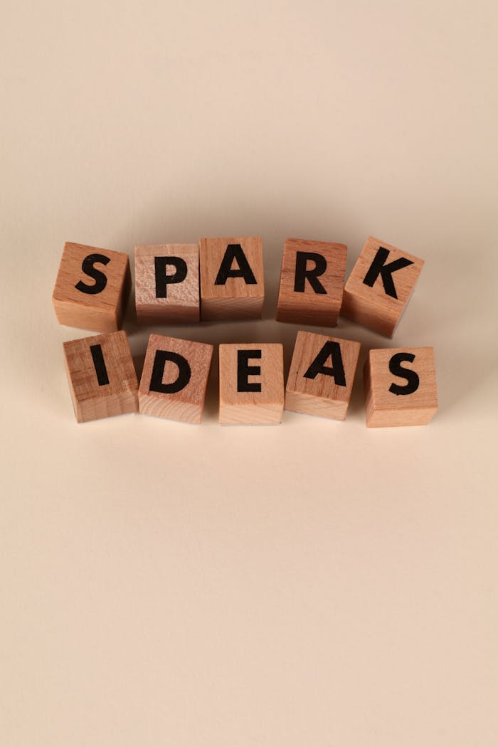 Wooden blocks spelling 'Spark Ideas' on a beige background, symbolizing creativity and inspiration.